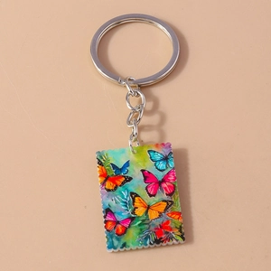Detail of square acrylic butterfly keychain with stamp-style edges and silver metal ring