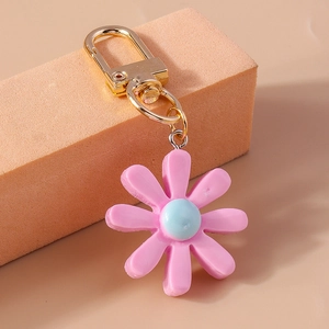 Nahaufnahme von rosa Harz-Gänseblümchen-Schlüsselanhänger mit goldener Metall-D-Schnalle
