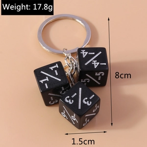 Macro detail of three black math dice with white numbered markings on a silver keychain