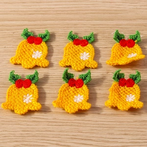 Detailed view of six yellow crochet bells with red flowers for DIY Christmas decor