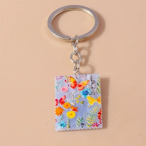 Detail of acrylic postage stamp style keychain with colorful butterflies and flowers