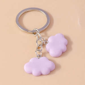 Detail view of light purple resin cloud pendants on a polished metal keychain