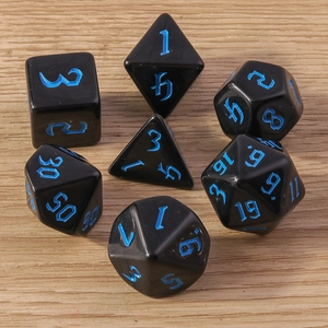 Set of seven black polyhedral dice with blue numbers on a rustic wooden table background