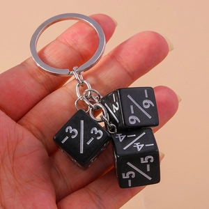 Detailed macro view of dice keychain with mathematical fraction symbols on black cubes