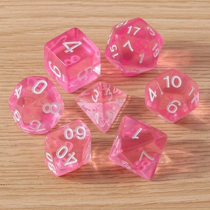 Set of 7 translucent pink polyhedral dice with white numbers on light wood background