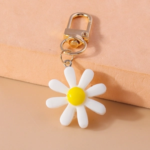 Detailansicht eines Gänseblümchen-Schlüsselanhängers mit weißen Blüten und Goldhaken
