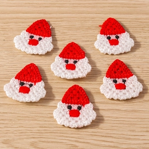 Macro detail of handmade crochet Santa Claus decorative patches for DIY holiday crafts