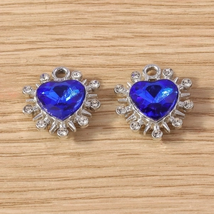 Dettaglio di pendenti in cristallo blu a forma di cuore con cornici in argento e strass