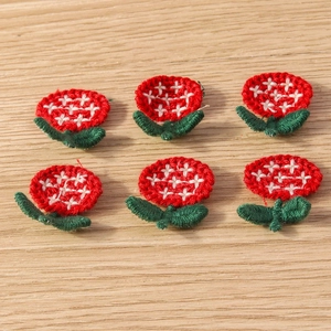 Detail of six red and green embroidered flower patches for DIY clothing decoration