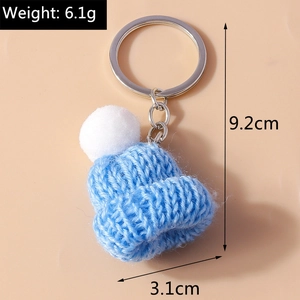 Detailed size view of blue knitted hat keychain with white pompom and silver ring