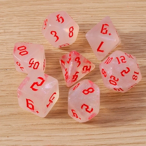 Detailed macro view of 7-piece pink glitter resin polyhedral dice for tabletop RPG games