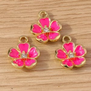 Close-up of three rose pink enamel flower charms with crystals and gold-plated edges