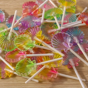 Macro shot of colorful shell-shaped resin lollipops with metallic rings for DIY jewelry