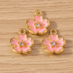 Detailed close-up of pink cherry blossom pendants with gold edges and inlaid crystal