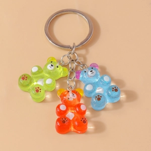 Three colorful translucent resin gummy bear keychains with glitter and silver metal rings