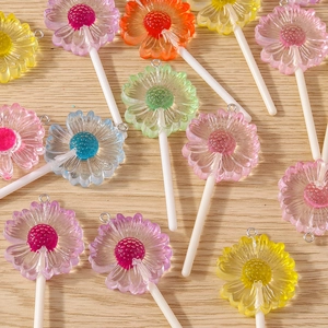 Colorful daisy lollipop resin flower charms for DIY jewelry making on wood background