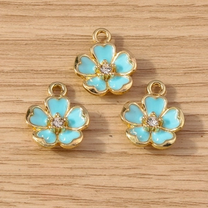 Macro detail of sky blue enamel flower pendants with gold plating and sparkling crystals