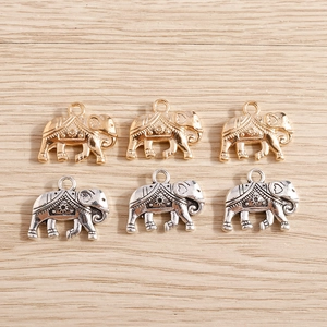 Set van olifant bedeltjes in goud en zilver voor DIY sieraden maken op houten ondergrond