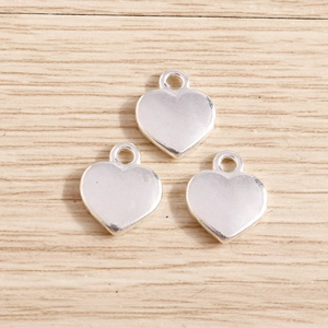 Minimalist silver heart alloy pendants for DIY jewelry making displayed on a wooden surface