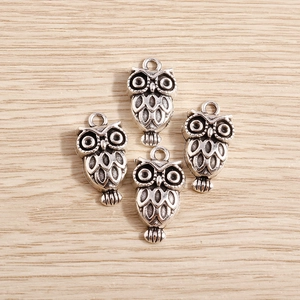 Detailed macro view of antique silver owl alloy pendants for vintage DIY jewelry making