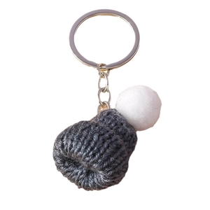 Handmade mini grey knitted beanie keychain with a white pom-pom on white background