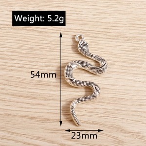 Macro detail of a silver snake pendant showing 54x23mm dimensions and scale texture