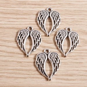 Détail des breloques cœur ailes d'ange rétro avec texture plume sur bois