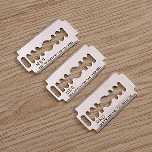 Three blade shaped stainless steel tags with MNG 20th anniversary engraving on wood