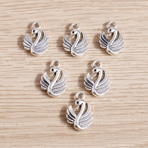 Set of 6 vintage silver swan pendants for DIY jewelry making on wood background
