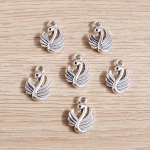 5Pcs antique silver swan charms for DIY jewelry making on a light wooden background