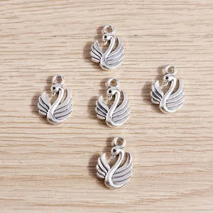 Detailed close-up of five antique silver swan charms for DIY jewelry making and crafts