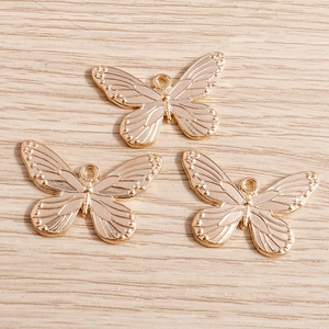 Detailed macro view of vintage textured butterfly charms in champagne gold finish