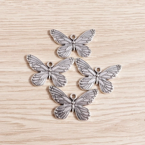 Macro detail of butterfly alloy pendants with vintage texture and hollow wing patterns