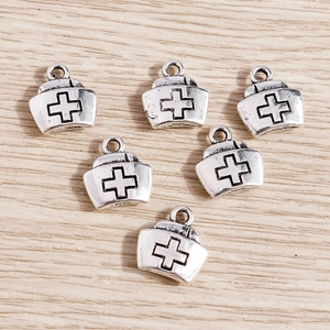 Retro silver alloy nurse hat charms with cross pattern on light wooden background