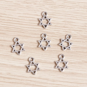 Vintage silver hollow star charms for jewelry making on light wood background