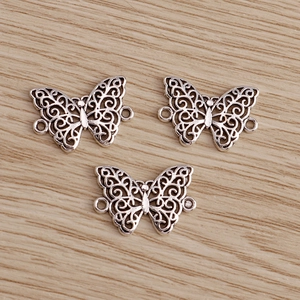 Retro butterfly alloy charms with hollow patterns and dual hanging loops for DIY jewelry