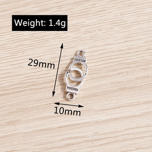 Macro detail of alloy handcuff charm with Freedom engraving and metal rings