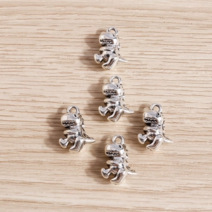 Five vintage silver alloy dinosaur pendants with cute cartoon tyrannosaurus design for DIY