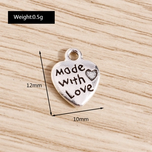 Macro shot of silver heart charm with Made with Love engraving and 12mm dimensions
