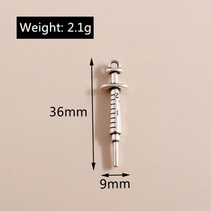 Macro detail of alloy syringe pendant showing 36mm length and engraved measurements