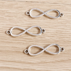 Conectores de colgante infinito en aleación plata antigua sobre fondo de madera