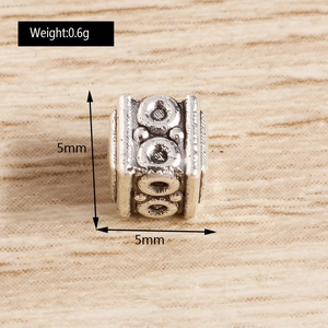 Macro detail of 5mm cube spacer bead with vintage patterns for DIY jewelry making