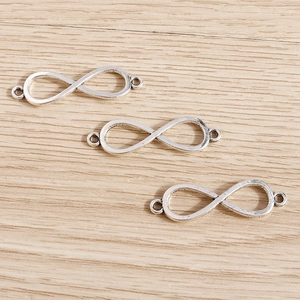 Conectores de joyería infinito en plata de ley con doble lazo sobre madera