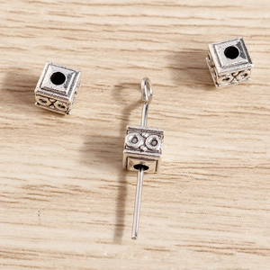 Macro detail of vintage silver square spacer beads with textured patterns for DIY jewelry
