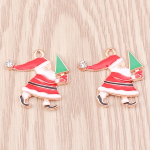 Détails macro de pendentifs Père Noël en or rose avec cristal incrusté sur fond bois clair