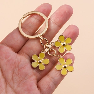 Golden keychain with yellow daisy pendants and floral charms for phone and bag accessories