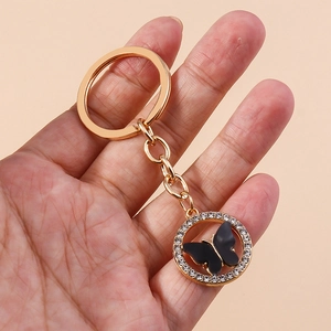 Detail of a sparkling acrylic butterfly keychain with rhinestones and gold metal ring