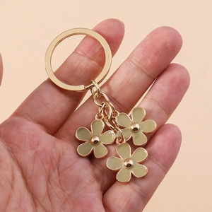 Pastel cherry blossom keychain with gold metal ring and yellow-green enamel flower charms