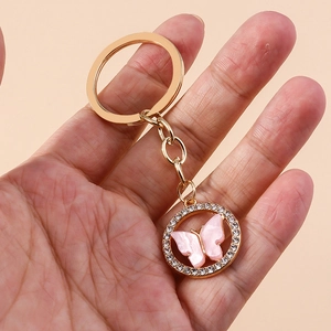 Elegant gold-tone butterfly keychain with pink resin inlay and sparkling rhinestones