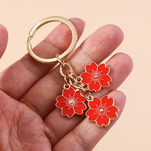 Porte-clés minimaliste fleurs de cerisier avec pendentifs rouges et anneaux dorés